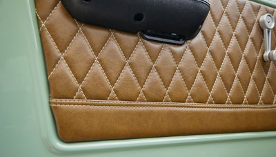Detailed view of tan quilted leather door panel inside Classic Ford Bronco.