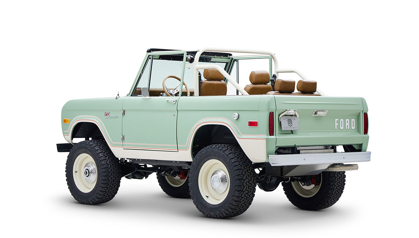 Classic Ford Bronco in porcelain green with tan seats, visible from rear left angle on white background