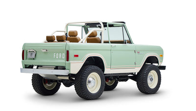 Classic Ford Bronco in porcelain green with tan seats, seen from rear right angle on white background