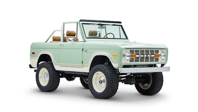 Classic Ford Bronco in porcelain green with tan seats, seen from front left angle on white background