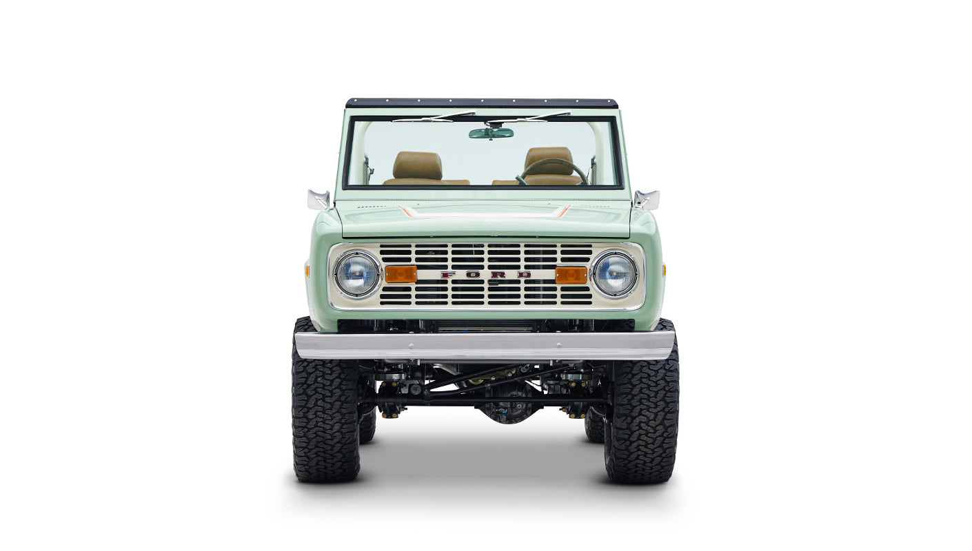 Front view of Classic Ford Bronco in porcelain green with tan seats on white background