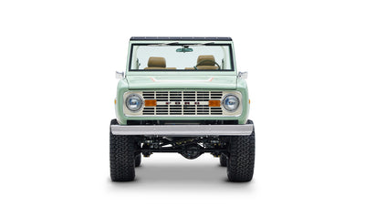 Front view of Classic Ford Bronco in porcelain green with tan seats on white background