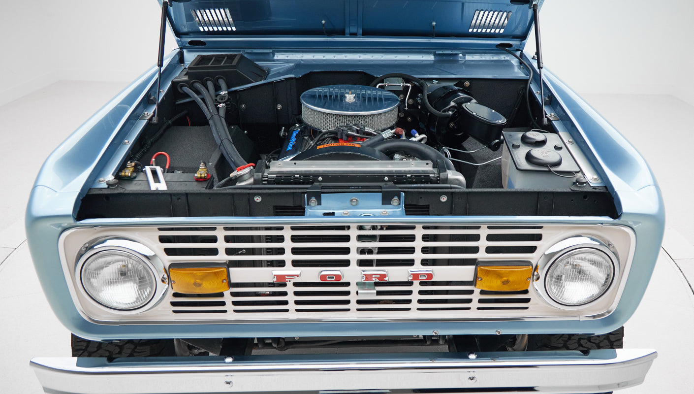 1973 Ford Bronco in Brittany Blue over Whiskey leather engine angle front
