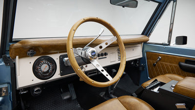 1973 Ford Bronco in Brittany Blue over Whiskey leather steering wheel