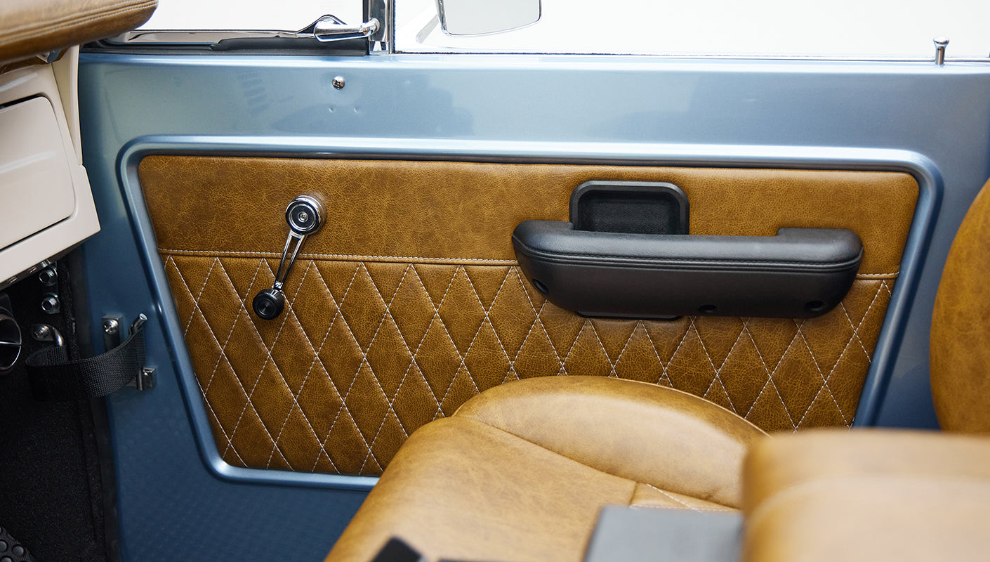 1973 Ford Bronco in Brittany Blue over Whiskey leather door panel detail