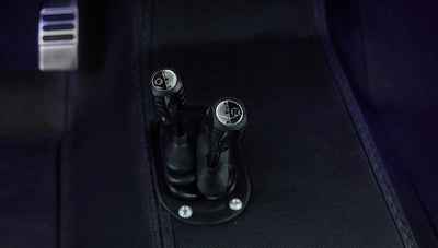 Two gear shift levers in Classic Ford Bronco interior with gear markings visible