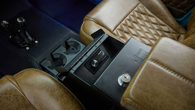 Close-up of center console with cup holders and Alpine audio controls inside Classic Ford Bronco