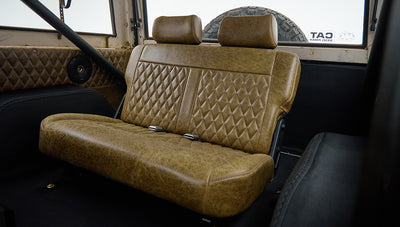 Classic Ford Bronco rear bench seat with brown leather upholstery and seat belts