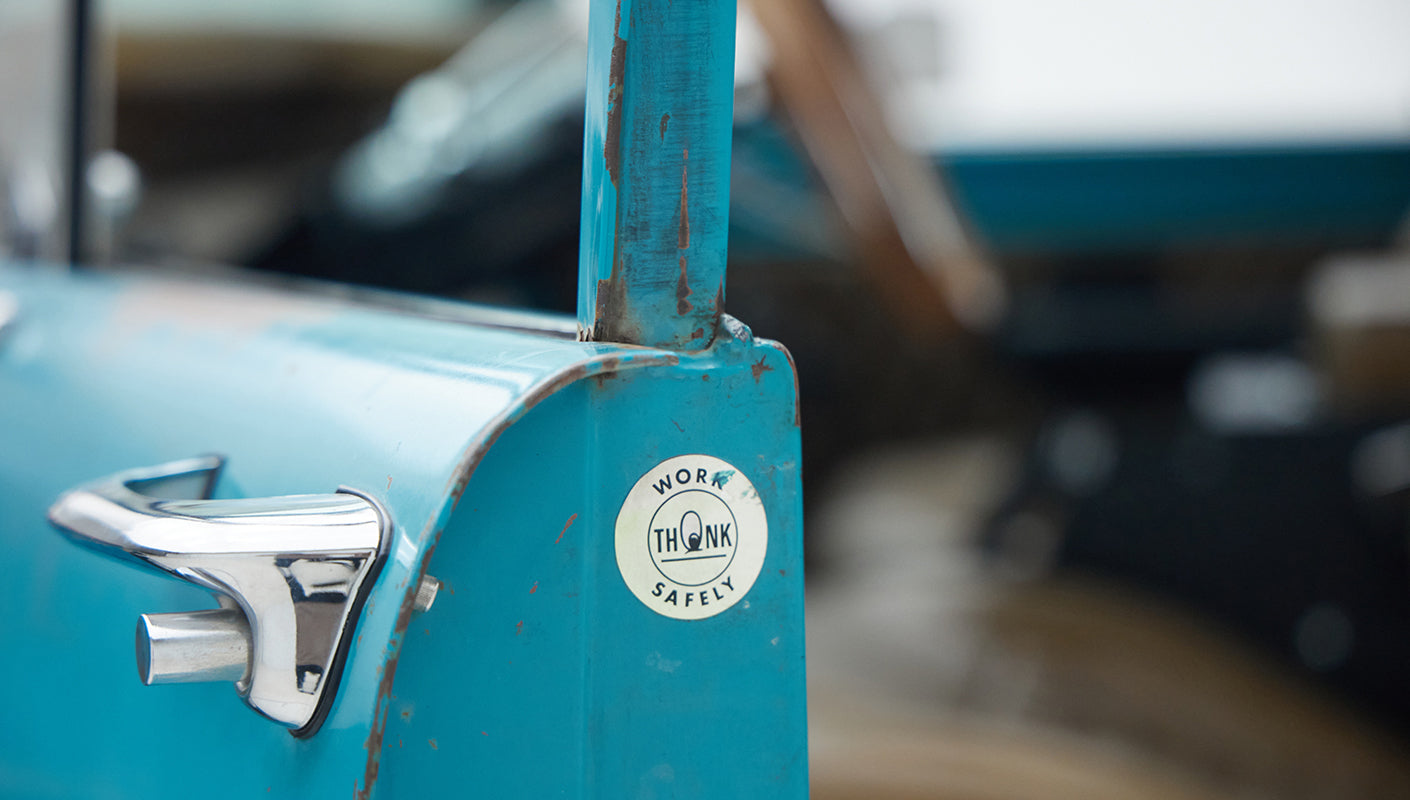Door handle and Work Think Safely sticker on turquoise doorframe of Classic Ford Bronco
