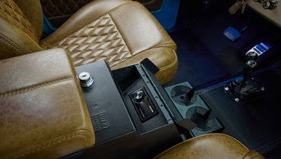 Center console features lockbox and cup holders amid vintage leather seats of Classic Ford Bronco