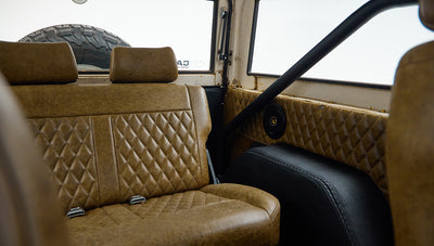 Rear bench seat with tan leather upholstery inside Classic Ford Bronco