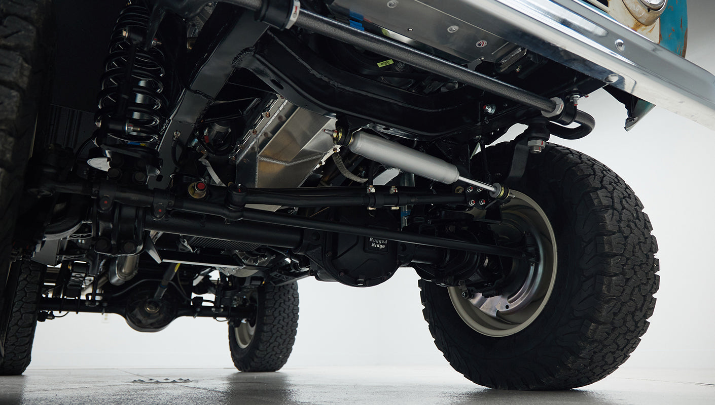 Undercarriage detail showing suspension and tires of Classic Ford Bronco in clean setting