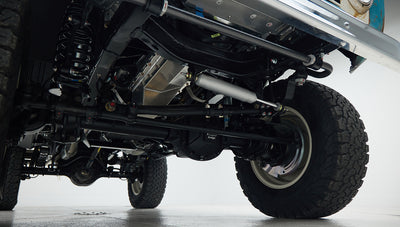 Undercarriage detail showing suspension and tires of Classic Ford Bronco in clean setting