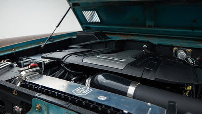 Classic Ford Bronco engine bay detail showing aluminum radiator with CFB logo and black hoses