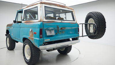 Rear quarter view of Classic Ford Bronco in turquoise patina with mounted spare tire and CFB Series plate