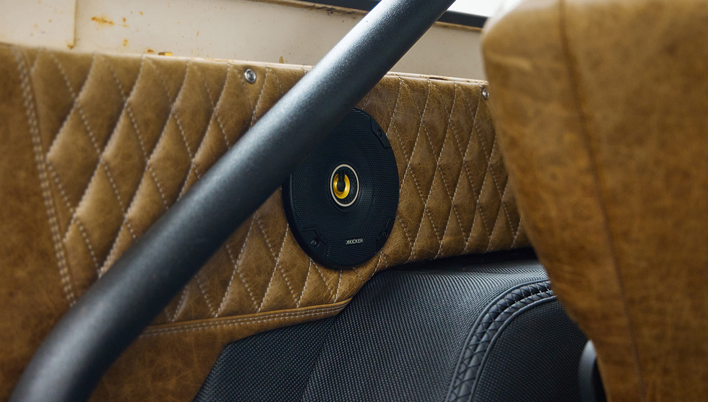 Speaker installed in tan leather panel and rear seat area inside Classic Ford Bronco