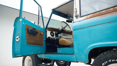 Passenger side open door showing tan leather interior and steering wheel inside Classic Ford Bronco