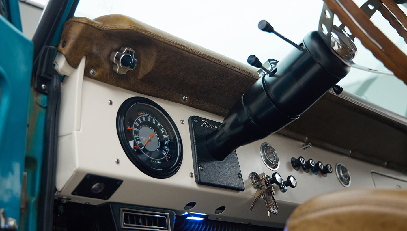 Dashboard with speedometer, ignition keys, and various switches and controls inside Classic Ford Bronco
