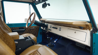 Tan leather front seats and dashboard area with gear shifters inside Classic Ford Bronco