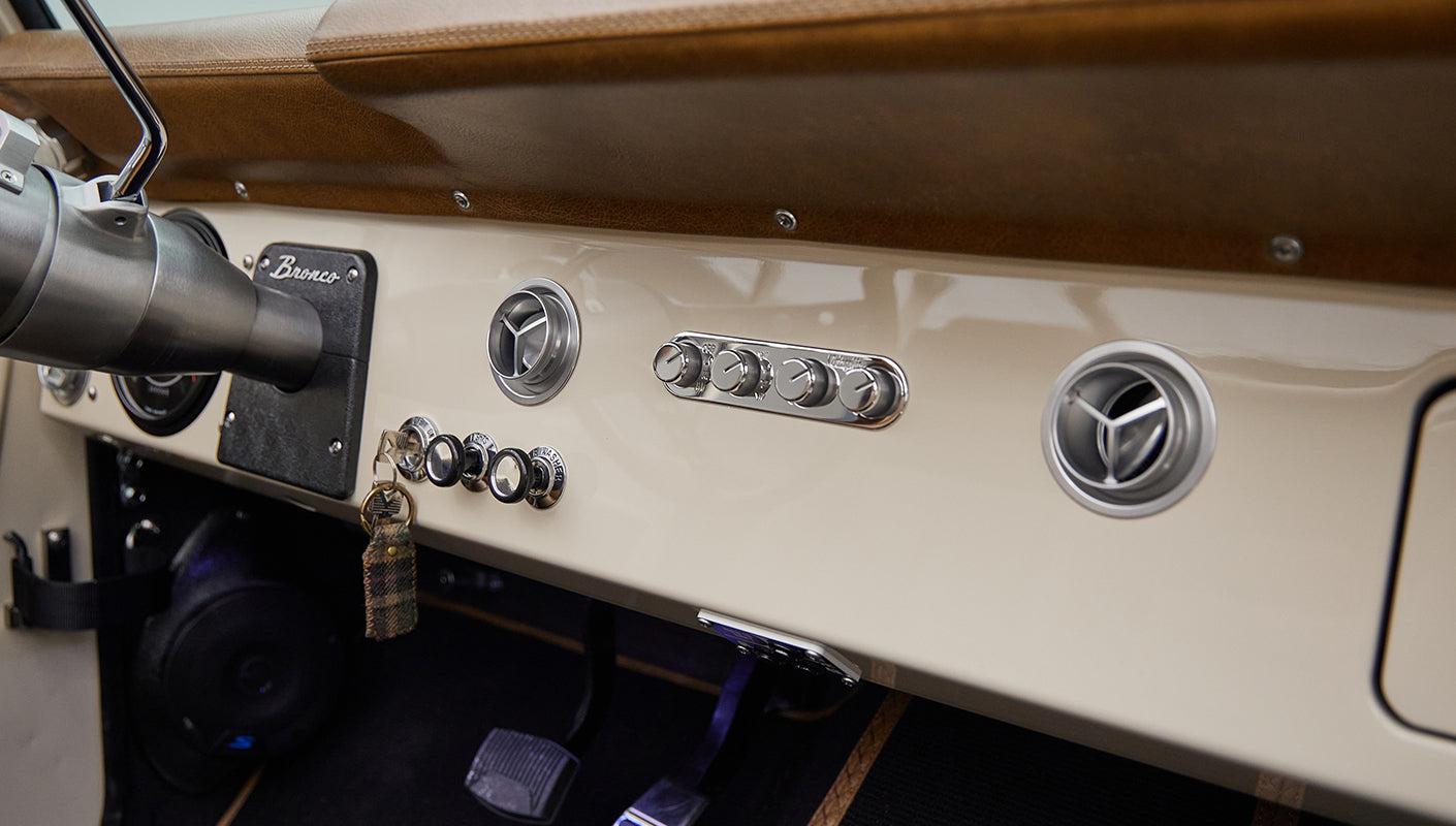Close-up of Classic Ford Bronco dashboard with metal knobs and vintage keychain