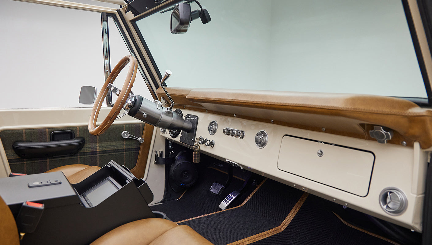 Classic Ford Bronco interior from passenger side, showing dashboard, steering wheel, and center console