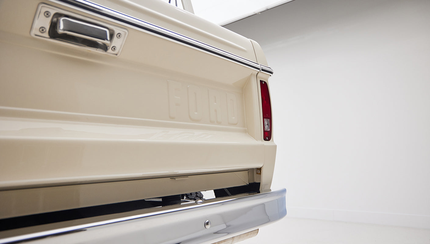 Close-up of rear tailgate and taillight of cream-colored Classic Ford Bronco with FORD embossed