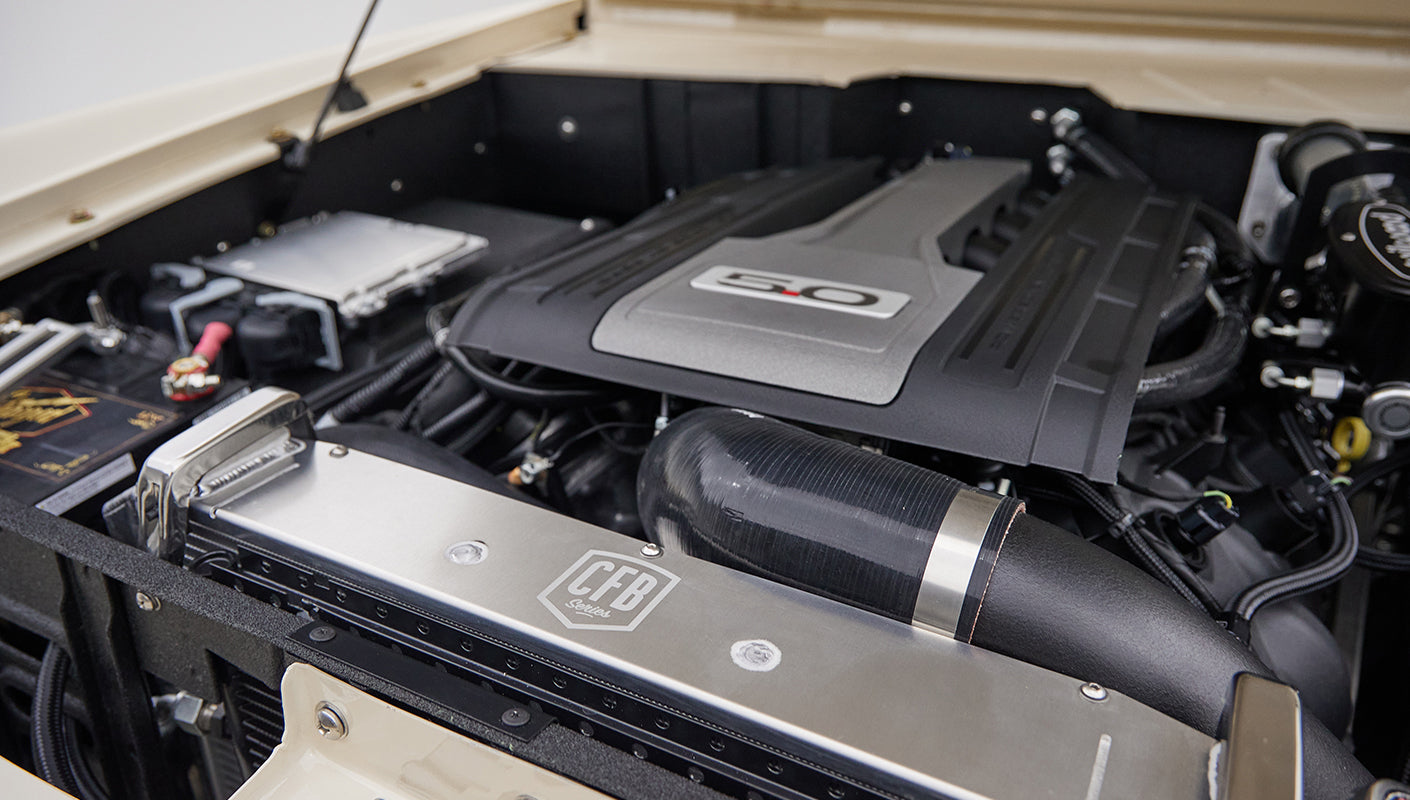 Close-up of Wilwood brake component and PSC power steering reservoir inside engine bay of Classic Ford Bronco