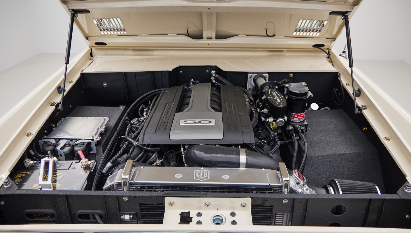 Front view under the open hood of Classic Ford Bronco highlighting 5.0 engine and clean engine bay