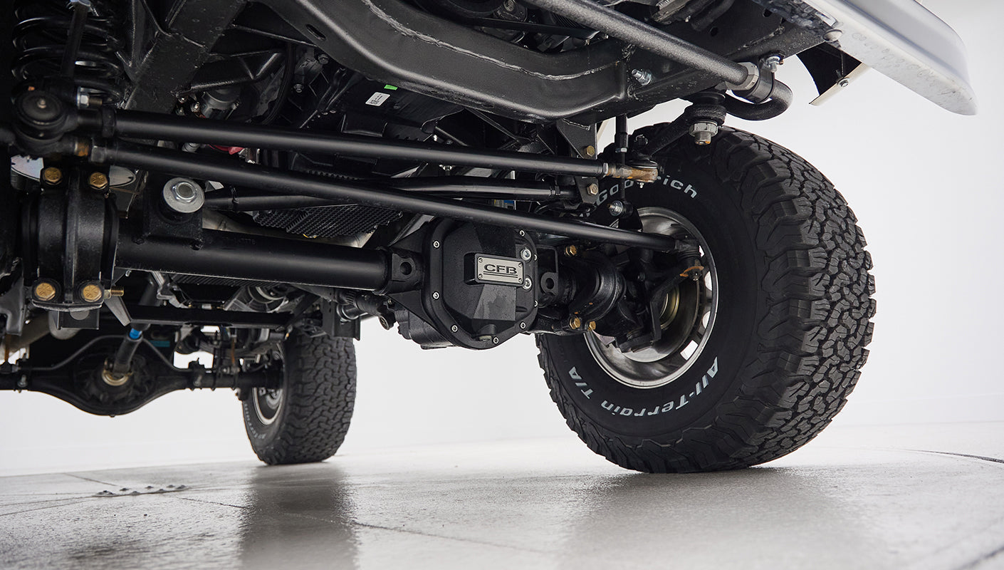 Side underneath view of Classic Ford Bronco showing front suspension and spare tire