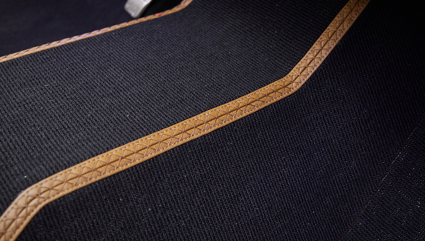 Close-up of black carpet with brown leather trim on Classic Ford Bronco floor
