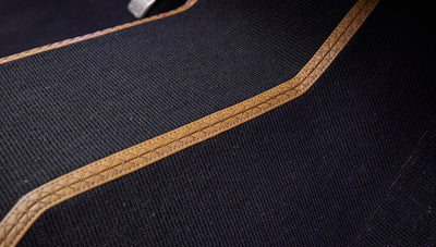 Close-up of black carpet with brown leather trim on Classic Ford Bronco floor