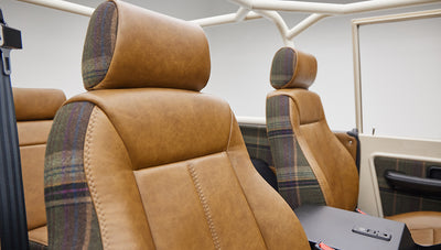 Close-up of tan leather seat backs and blanket plaid pattern on Classic Ford Bronco seats
