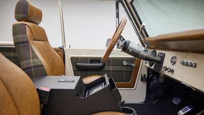 Passenger side view of Classic Ford Bronco interior with tan leather seats and plaid accents