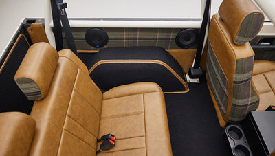 Interior rear seating area with tan leather and plaid upholstery in Classic Ford Bronco