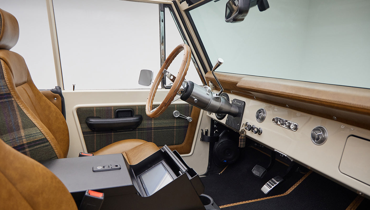 Driver side interior of Classic Ford Bronco with steering wheel and dashboard visible