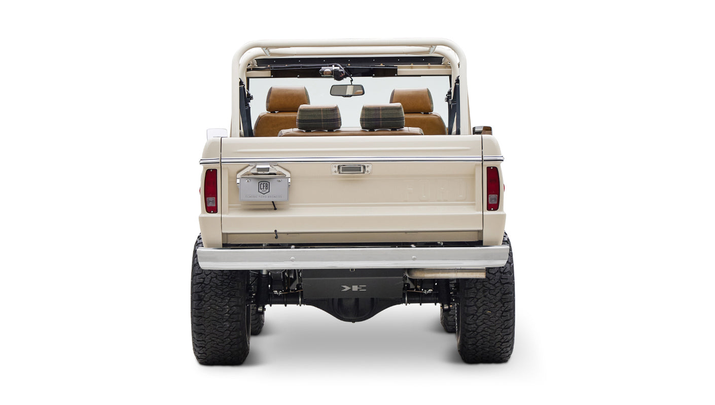 Classic Ford Bronco cream color rear view showing tailgate, bumper, and tires on white background