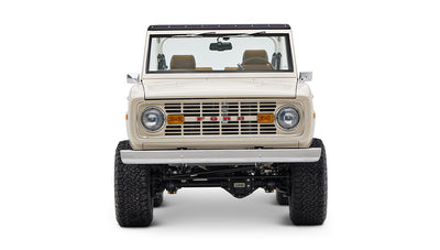 Classic Ford Bronco cream color front view showing grille, headlights, and large tires on white background