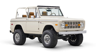 Classic Ford Bronco cream color with brown seats and open roof shown from front-left angle on white background