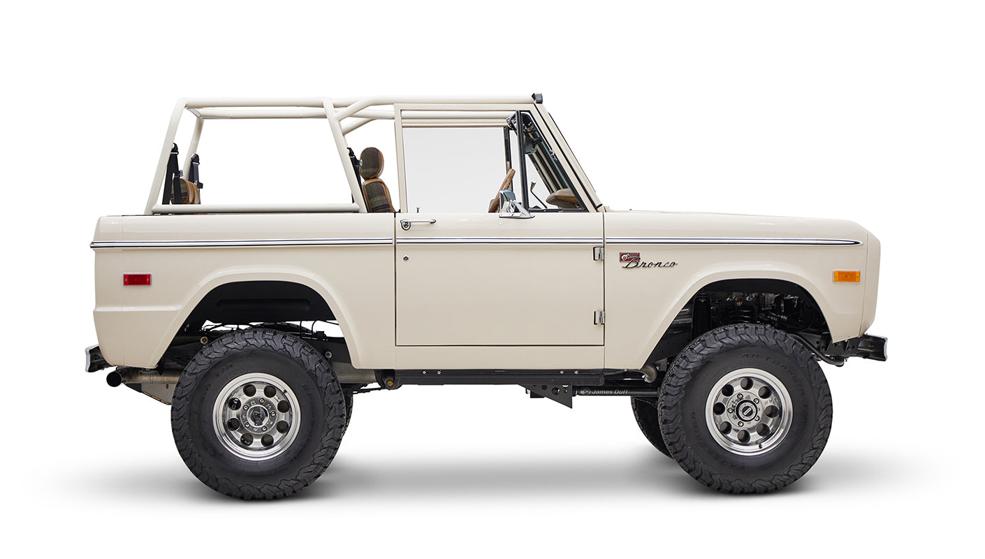 Classic Ford Bronco cream color in side view with focus on passenger side on white background
