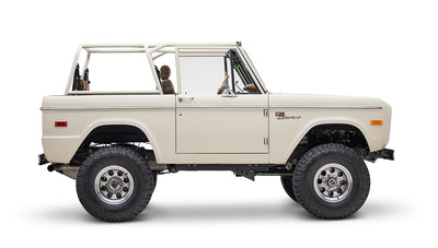 Classic Ford Bronco cream color in side view with focus on passenger side on white background