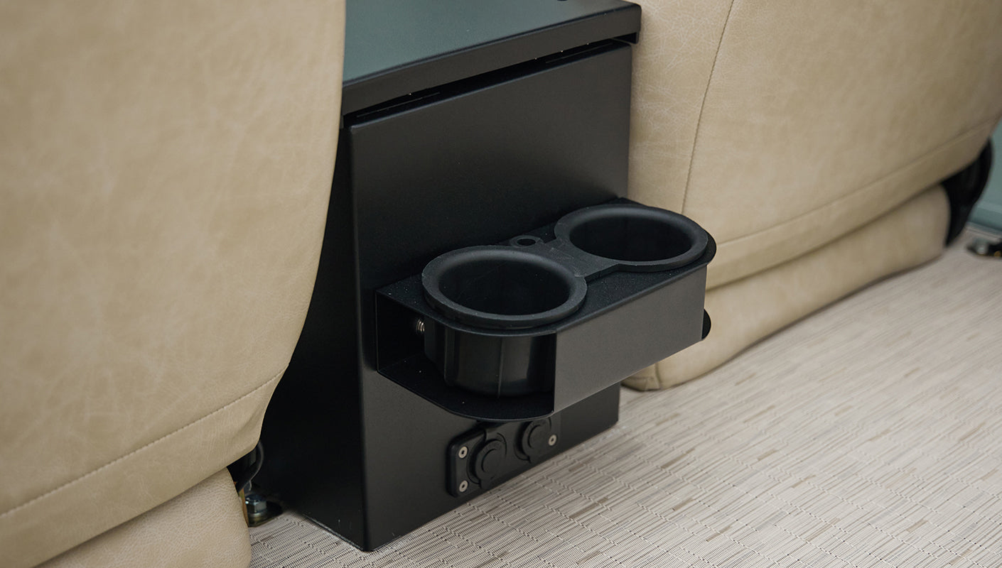 Black double cup holder mounted on black center console between beige seats in Classic Ford Bronco