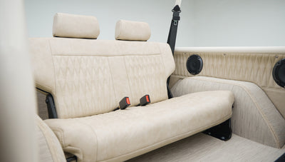 Beige upholstered rear seat with diamond pattern stitching and two headrests inside Classic Ford Bronco