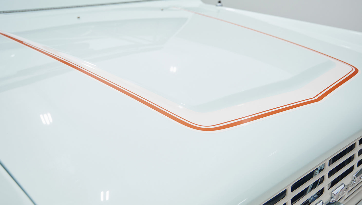 Close-up on hood with raised center indentation and orange pinstriping on Classic Ford Bronco