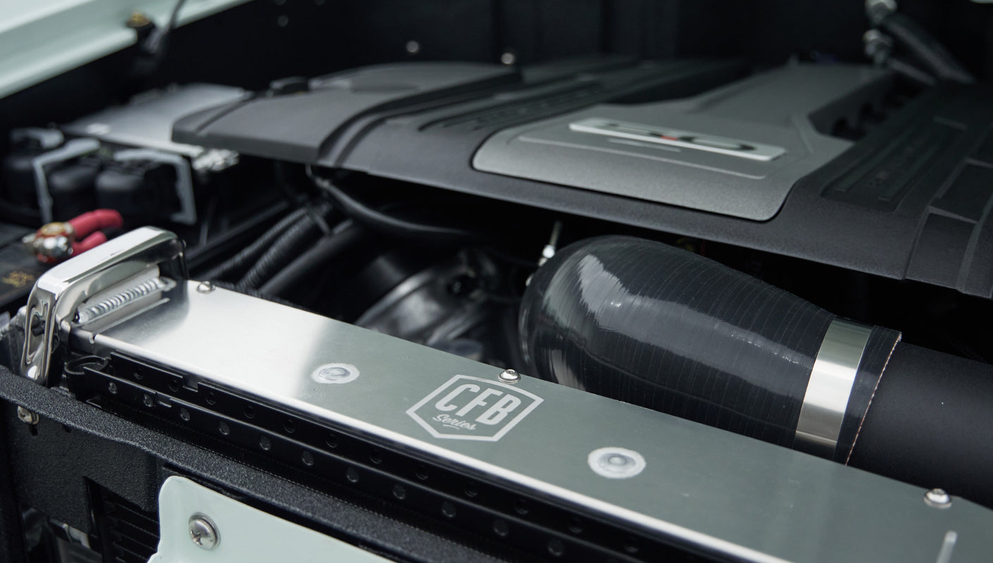 Detailed shot of radiator support with CFB logo and black air hose in Classic Ford Bronco