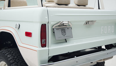 Rear quarter panel of Classic Ford Bronco showing tail light, fuel cap, and license plate holder