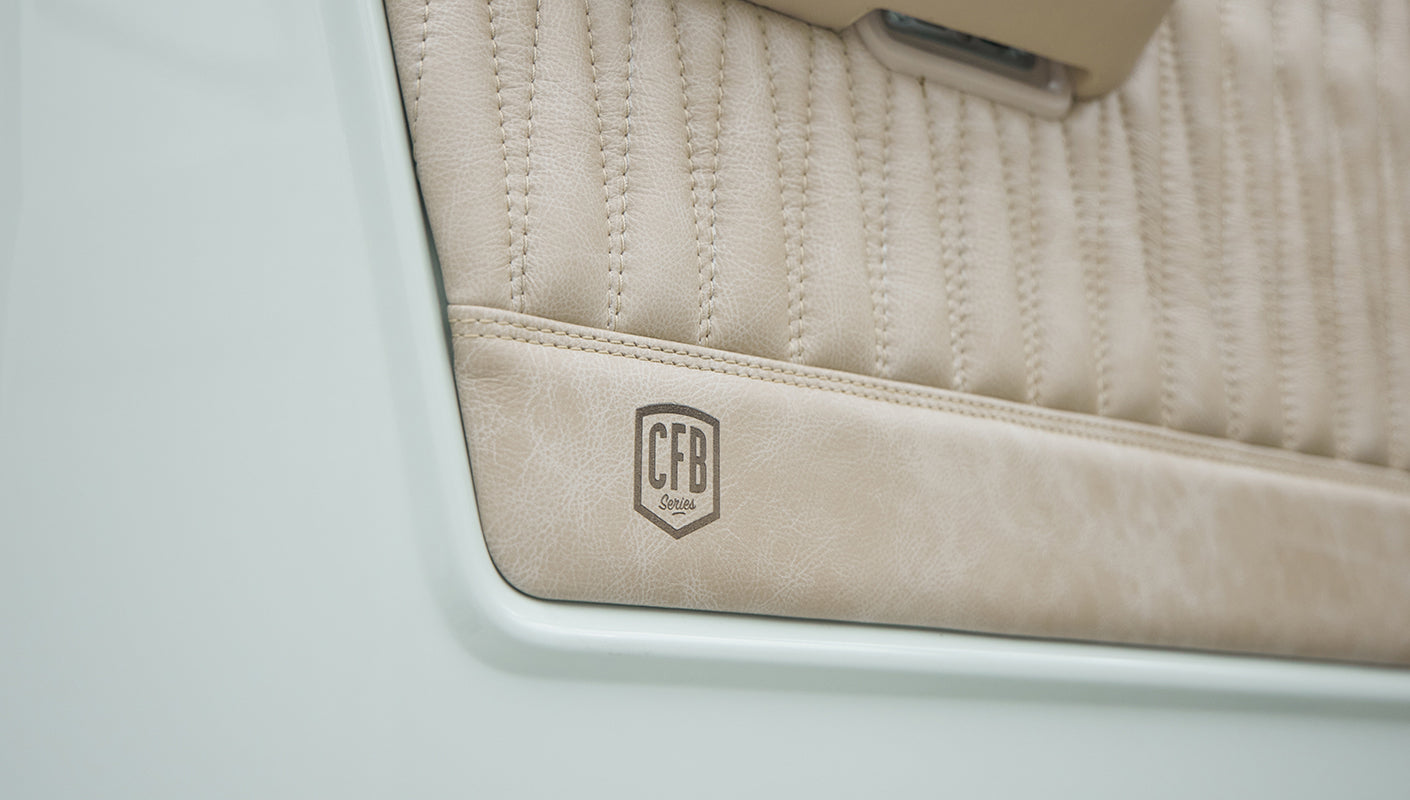 Close-up of beige door panel with stitched pattern and CFB Series logo on Classic Ford Bronco