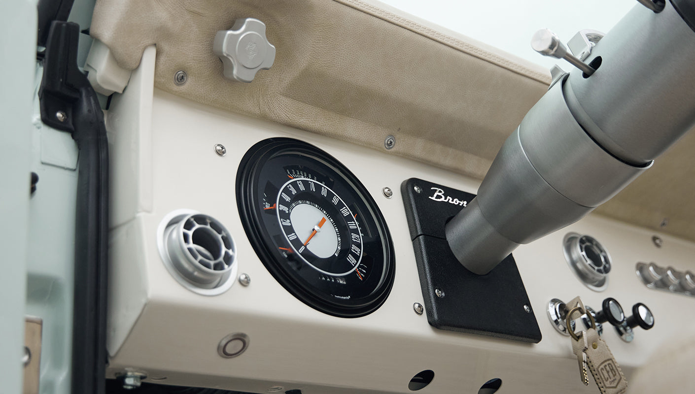 Classic Ford Bronco dashboard showing speedometer, air vent, and part of steering column