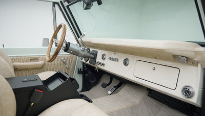 Classic Ford Bronco front seats and dashboard with wooden steering wheel and beige interior