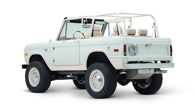 Rear three-quarter view of white Classic Ford Bronco 1974 Diamondblue Coyote Series with open back
