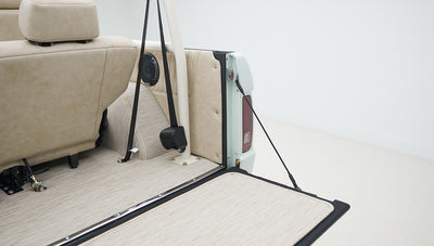 Close-up of rear interior area of a Classic Ford Bronco with beige upholstery and tailgate down.